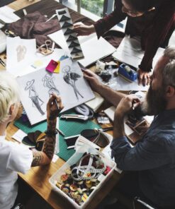 Fashion entrepreneur with coach brainstorming fashion design sketches for fashion product development.