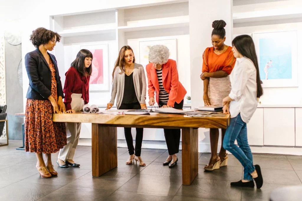 Group of woman designers working on a garment Yushkova Designs