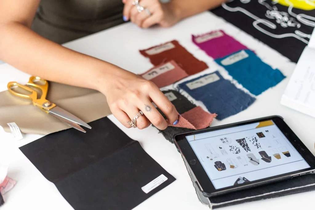 pexels-cristian-rojas-8030145 fashion assortment planning using a tablet while choosing the colour of fabric