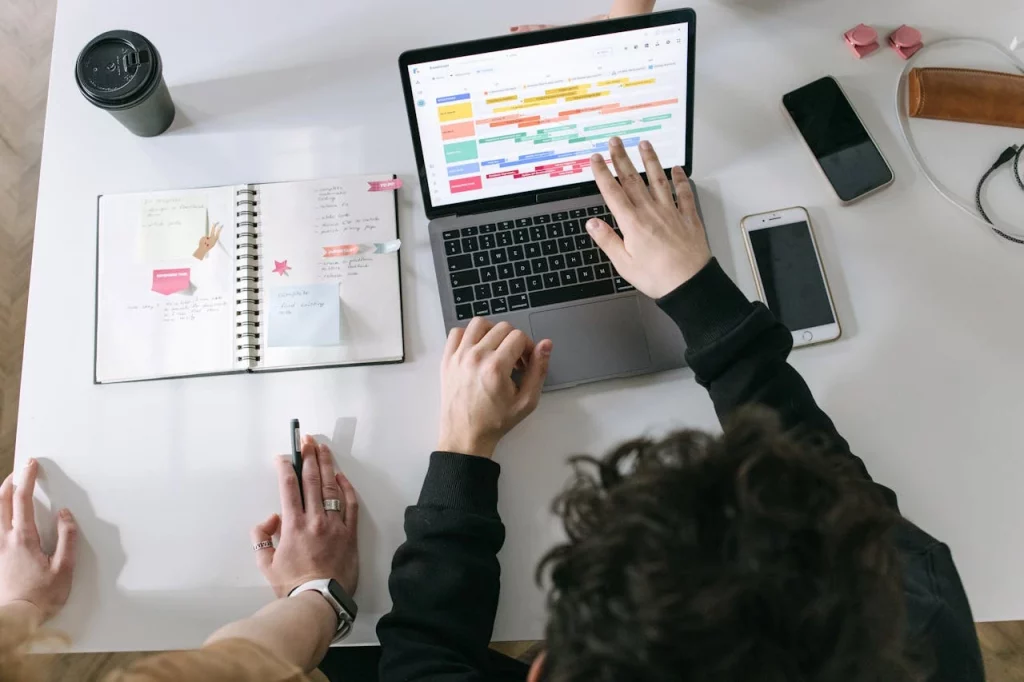 pexels-ivan-samkov-7213549 SAP Inventory Management software being studied on an apple laptop while kept on a white board next to a diary and two phones