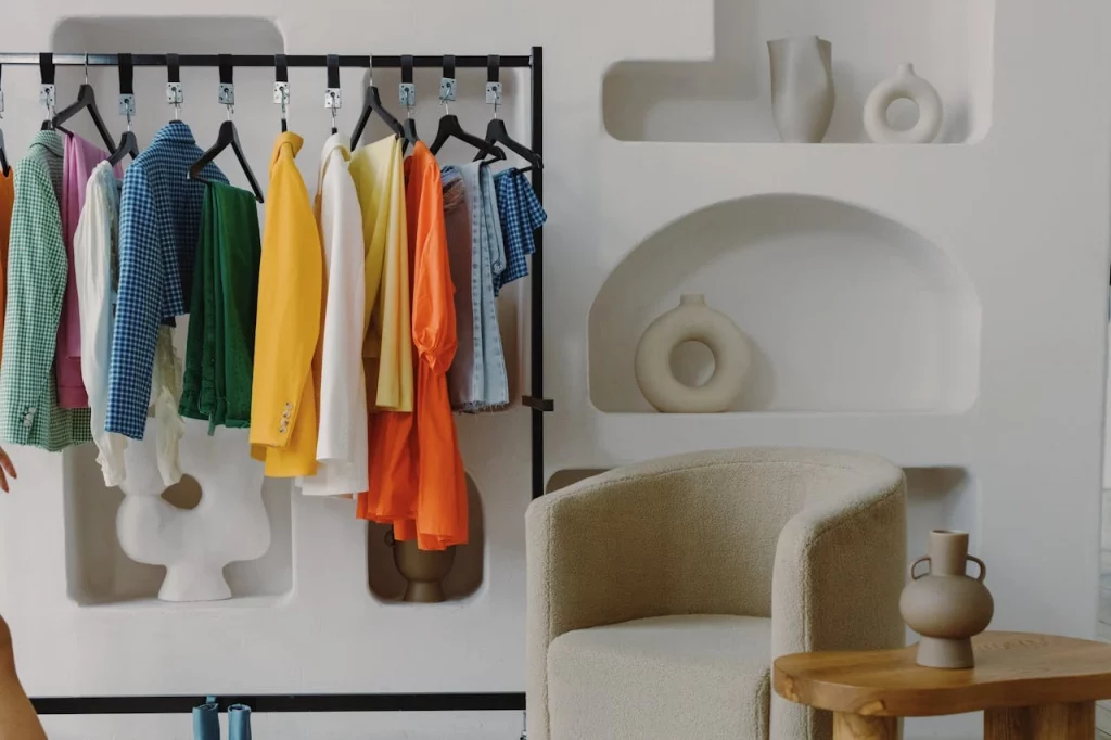 Yushkova Designs Using Circular Design Principles to manage a fashion business and an image of clothes hanging off a rack in a very modular store