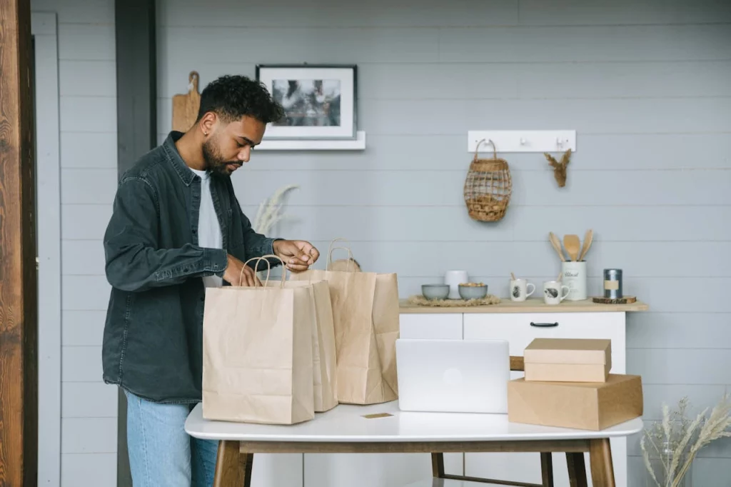 ivan-samkov-7621008 biodegradable packaging suppliers where a man in grey jacket and blue jeans looking at the packaging of pager bags